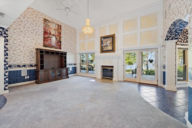 unfurnished living room with a towering ceiling, dark carpet, and crown molding