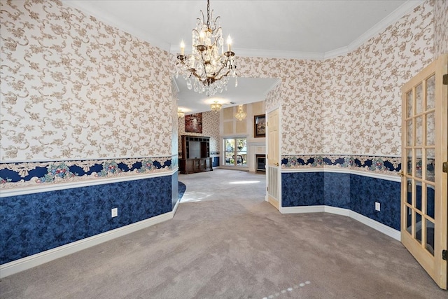 unfurnished dining area with crown molding, a chandelier, and carpet floors