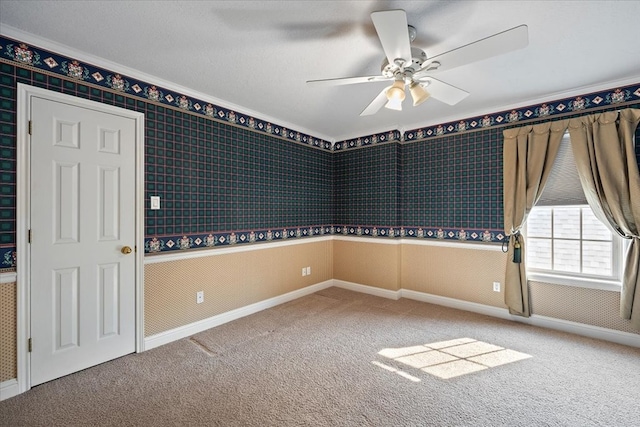 empty room featuring carpet floors, ornamental molding, and ceiling fan