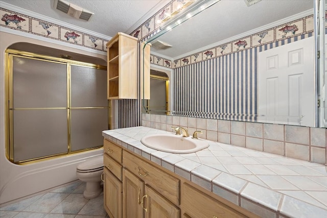 full bathroom featuring a textured ceiling, vanity, bath / shower combo with glass door, toilet, and crown molding