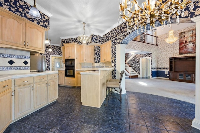 kitchen with light brown cabinetry, decorative light fixtures, and tasteful backsplash