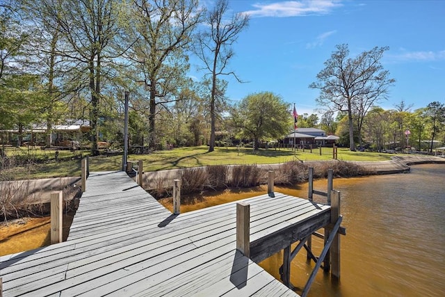 dock area with a lawn and a water view