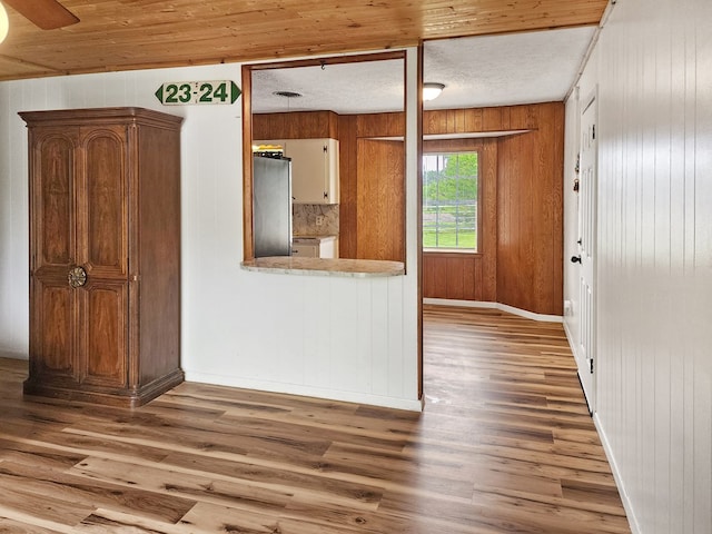 4296 US Highway 190 W, Jasper, TX 75951 - kitchen with freestanding refrigerator, wood finished floors, wooden walls, and baseboards