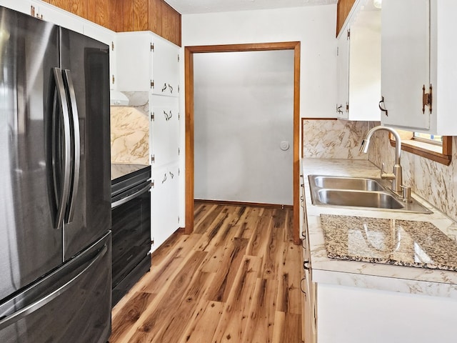 4296 US Highway 190 W, Jasper, TX 75951 - kitchen with freestanding refrigerator, a sink, stove, light countertops, and white cabinets