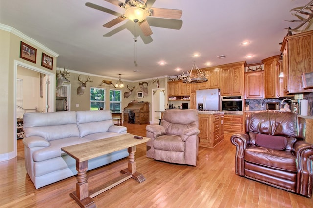 living room with ceiling fan with notable chandelier, light wood-type flooring, and ornamental molding