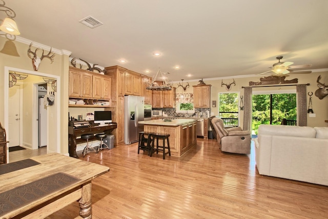 living room featuring ceiling fan, crown molding, and light hardwood / wood-style flooring