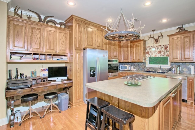 kitchen with a center island, stainless steel appliances, light hardwood / wood-style flooring, a notable chandelier, and a kitchen bar