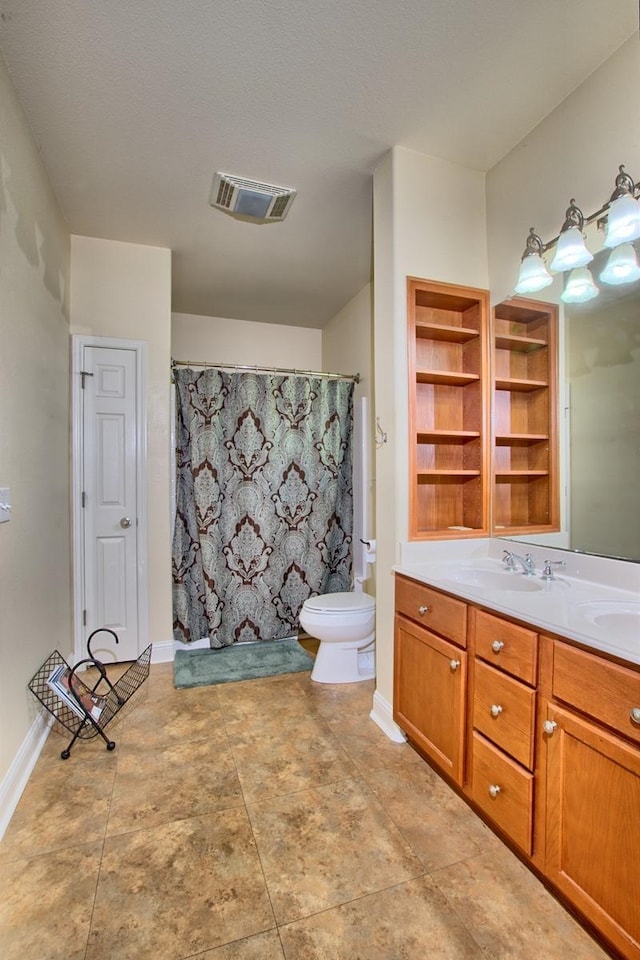 bathroom with vanity, a textured ceiling, and toilet