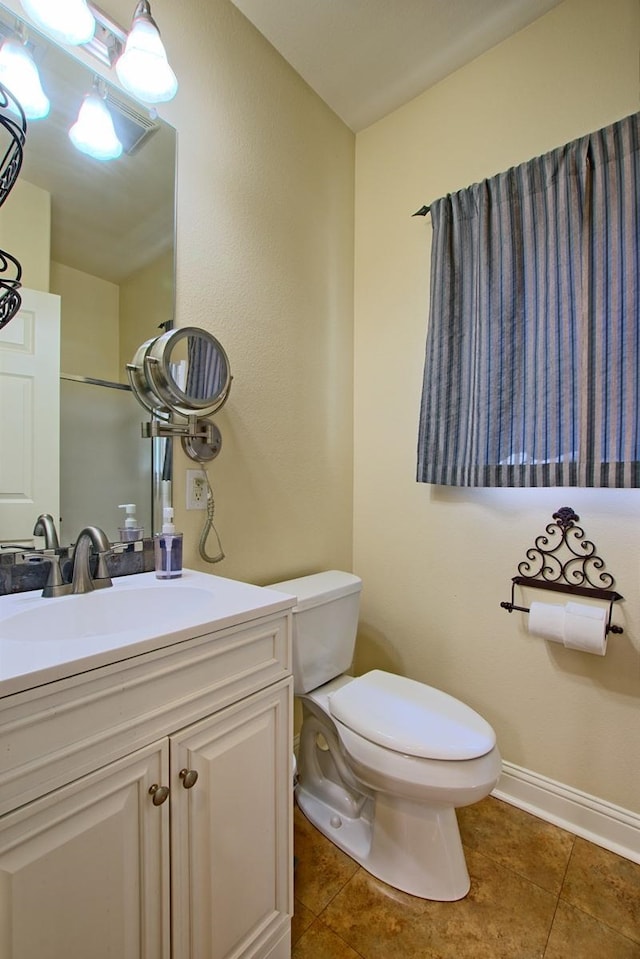 bathroom featuring tile patterned floors, vanity, and toilet