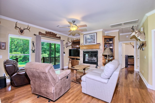 living room with ceiling fan, ornamental molding, and light wood-type flooring