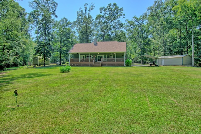 exterior space with a yard, a storage unit, a porch, and a carport