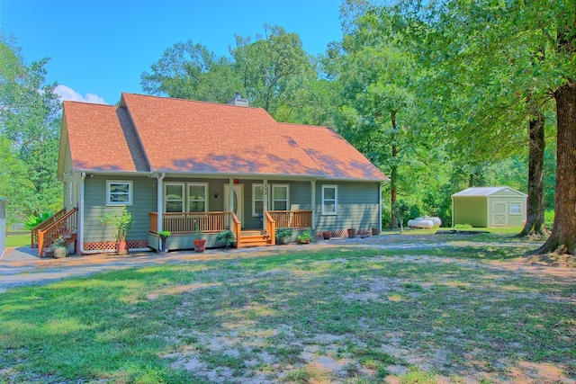 view of front of home featuring a front yard, a porch, and a storage shed