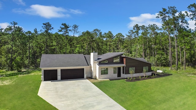 150 Tatanka Trl, Brookeland, TX 75931 - view of front of house with a chimney, driveway, a garage, and a front yard