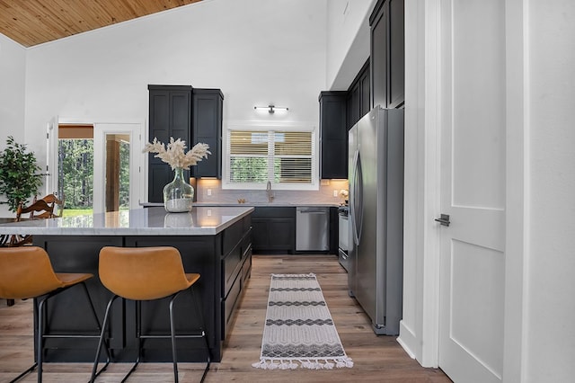 150 Tatanka Trl, Brookeland, TX 75931 - kitchen with stainless steel appliances, dark cabinets, lofted ceiling, a center island, and plenty of natural light