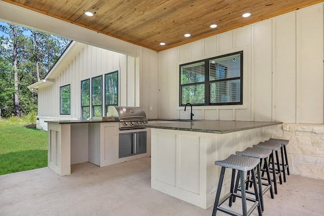 150 Tatanka Trl, Brookeland, TX 75931 - kitchen with wood ceiling, recessed lighting, a sink, unfinished concrete floors, and a kitchen bar