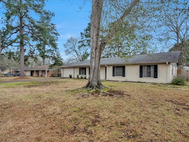 single story home with a garage, a front lawn, and brick siding