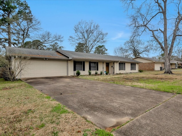 view of front of home with a front lawn, brick siding, driveway, and an attached garage