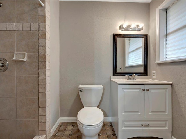 full bath with baseboards, toilet, tile patterned flooring, a tile shower, and vanity