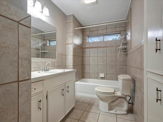 bathroom with toilet, bathing tub / shower combination, vanity, tile walls, and tile patterned floors