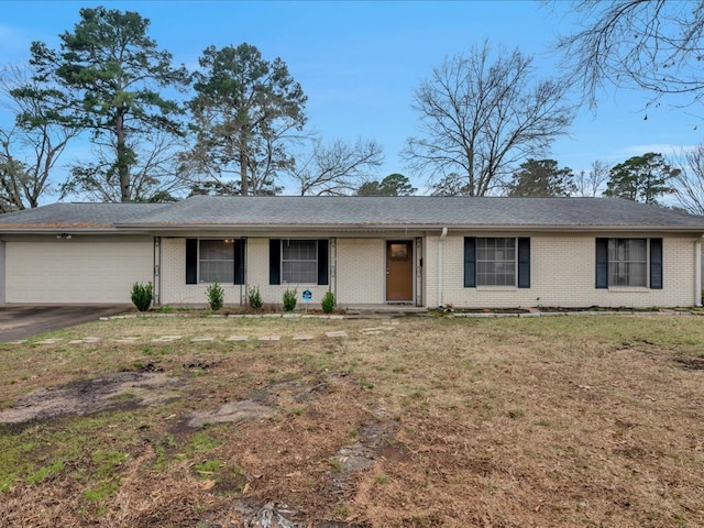 ranch-style home featuring a garage, brick siding, driveway, and a front yard