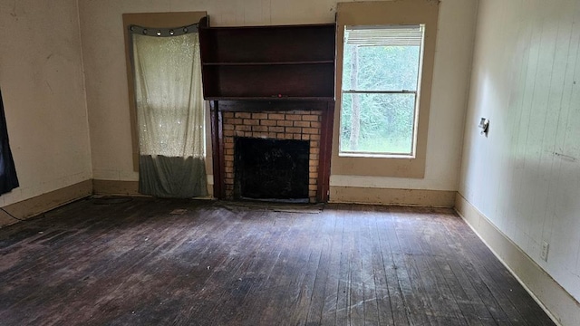 unfurnished living room with dark hardwood / wood-style floors, plenty of natural light, and a fireplace