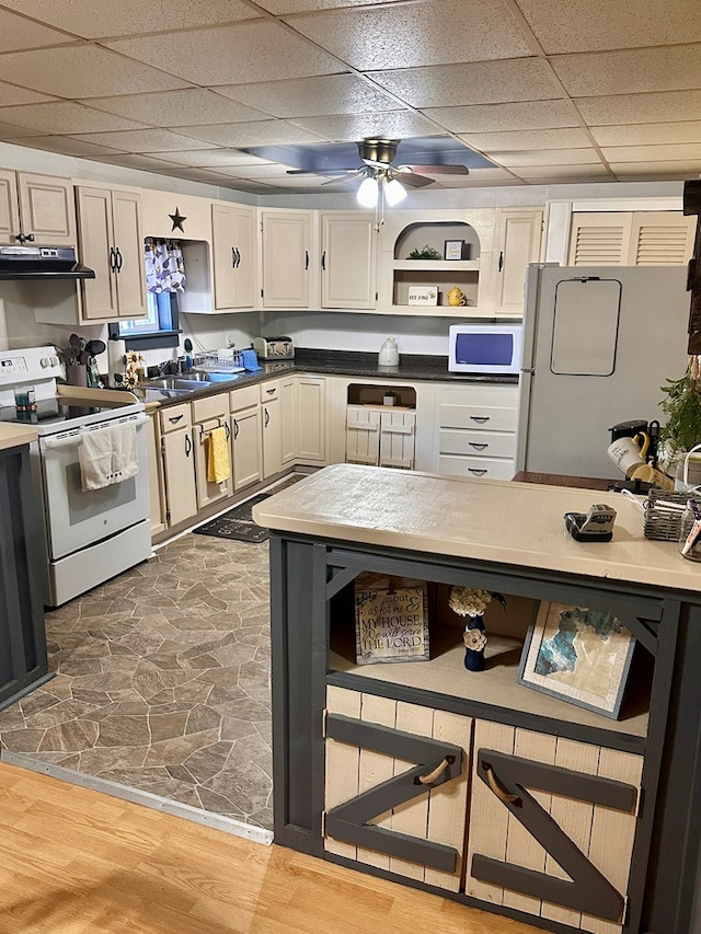 kitchen featuring hardwood / wood-style flooring, a paneled ceiling, ceiling fan, and white appliances