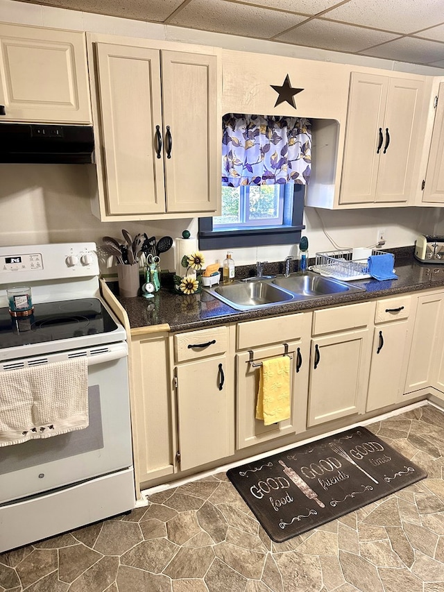 206 Perkins St, Zavalla, TX 75980 - kitchen featuring white electric stove, under cabinet range hood, dark countertops, a paneled ceiling, and stone finish flooring