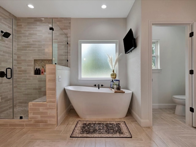 bathroom featuring a healthy amount of sunlight, toilet, and independent shower and bath