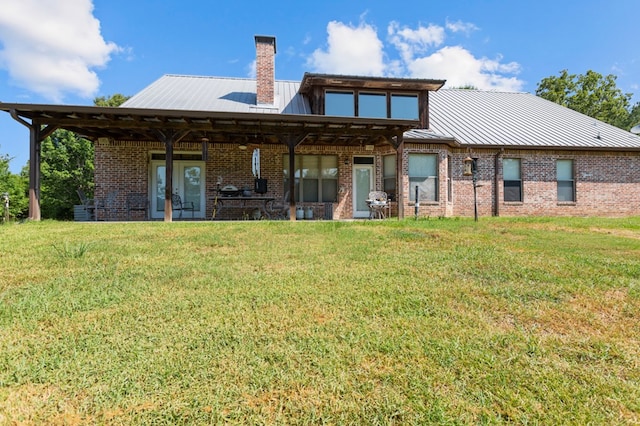 474 Mountain View Rd, Lufkin, TX 74904 - rear view of house with brick siding, a lawn, a chimney, and metal roof