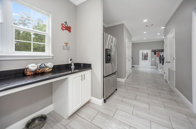 kitchen with ornamental molding, dark countertops, washer / clothes dryer, stainless steel refrigerator with ice dispenser, and recessed lighting