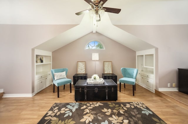 sitting room with a ceiling fan, baseboards, vaulted ceiling with beams, and light wood finished floors