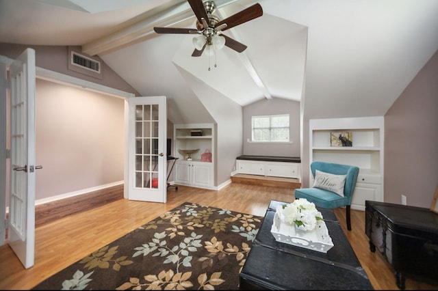 living area with french doors, visible vents, built in features, wood finished floors, and vaulted ceiling with beams