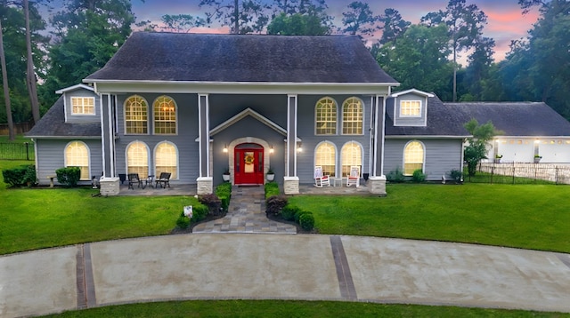 view of front of house with a porch, fence, and a front lawn