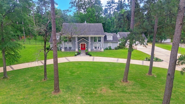 view of front of home featuring curved driveway and a front yard