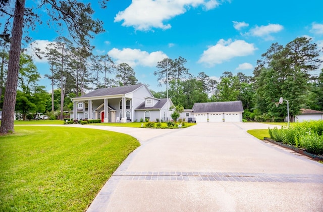 greek revival inspired property with a detached garage, curved driveway, and a front yard