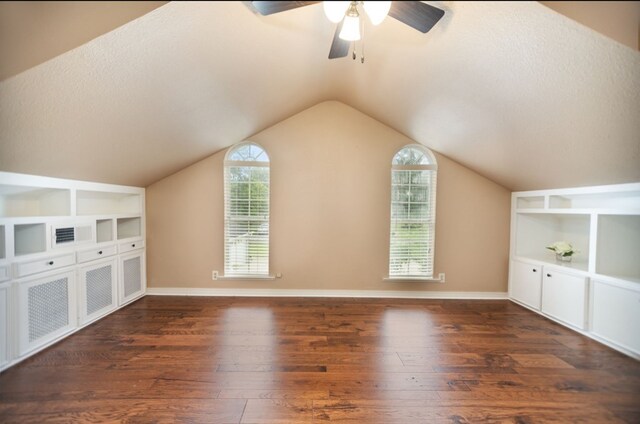 additional living space with built in features, wood finished floors, baseboards, ceiling fan, and vaulted ceiling