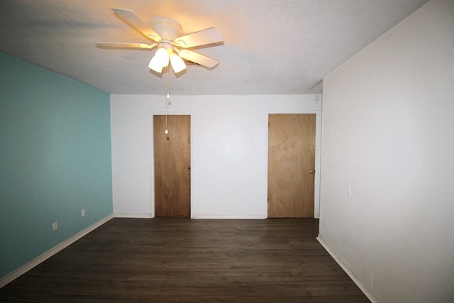 unfurnished room featuring dark wood-type flooring, ceiling fan, and a textured ceiling