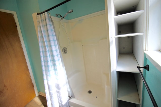 bathroom with hardwood / wood-style flooring and curtained shower