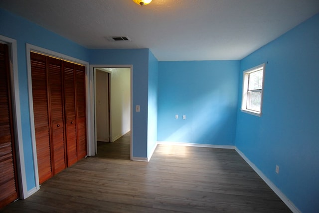 unfurnished bedroom with dark hardwood / wood-style floors