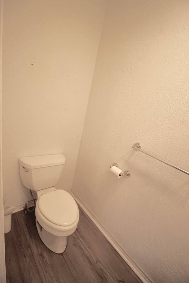 bathroom featuring hardwood / wood-style flooring and toilet