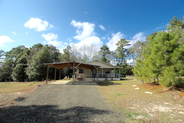 view of front of home featuring a porch, a carport, and a front yard