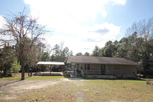 view of front of property featuring a carport, covered porch, and a front yard