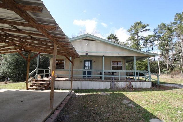 back of house featuring a lawn and covered porch