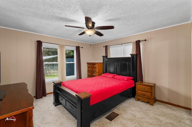 bedroom featuring ceiling fan, crown molding, and light colored carpet