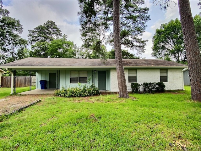 ranch-style home featuring a carport and a front yard