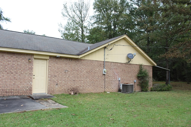 exterior space featuring cooling unit and a yard