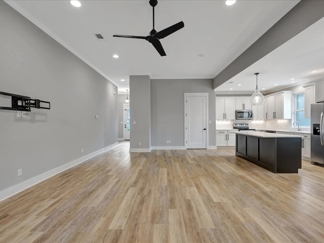 829 Village Gate Cir, Nacogdoches, TX 75961 - kitchen featuring stainless steel appliances, a ceiling fan, light countertops, a kitchen island, and a sink