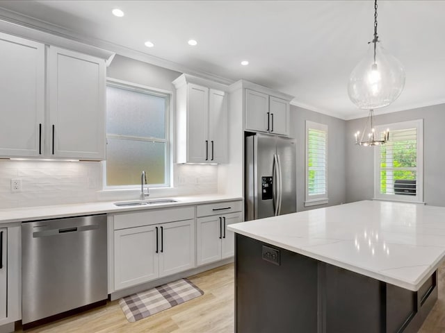 829 Village Gate Cir, Nacogdoches, TX 75961 - kitchen featuring appliances with stainless steel finishes, a sink, crown molding, tasteful backsplash, and light wood-style floors