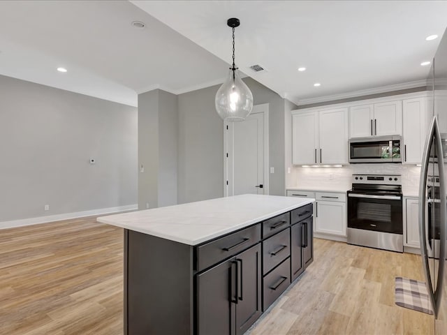 829 Village Gate Cir, Nacogdoches, TX 75961 - kitchen featuring stainless steel appliances, white cabinets, light wood-style floors, ornamental molding, and pendant lighting