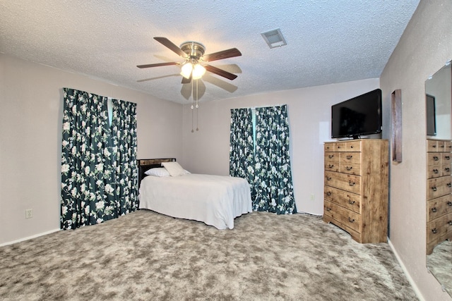 carpeted bedroom featuring a textured ceiling and ceiling fan